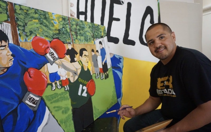 Melendrez painting an image of boxers.