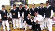 Marimba Primaveral de Guatemala pose wearing traditional white outfits and black vests.