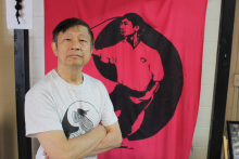 Leung stands in front of a red poster.
