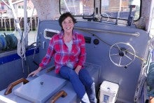Terri Stone smiling while sitting on a fishing boat