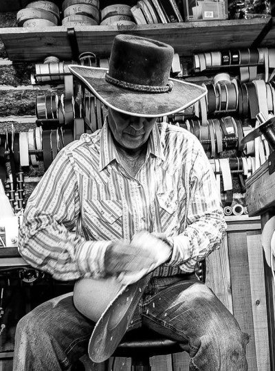 Lisa Robinson sitting on a stool, shaping a hat