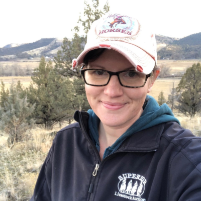 Clair Kehrberg headshot in the outdoors with trees and mountains in the backdrop