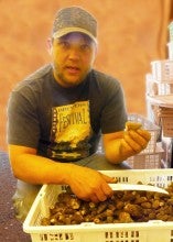 Bryan standing behind basket full of mushrooms, wearing a grey t-shirt that reads "Oregon Brewers Festival"