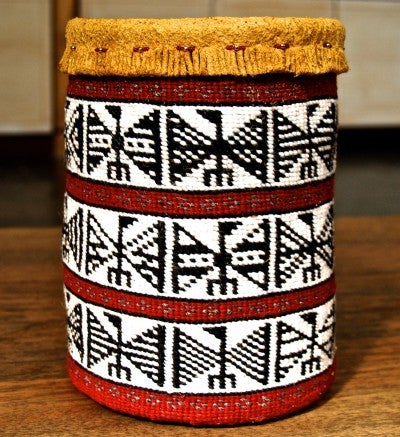 A red, white, and black patterned woven basket.