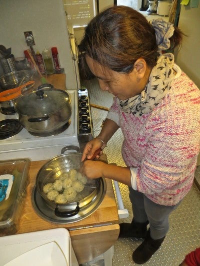 Ang Diki Sherpa cooking momo dumplings in a steam pan