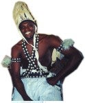 Alseny wearing a forokotoba hat and traditional clothing with shells. 